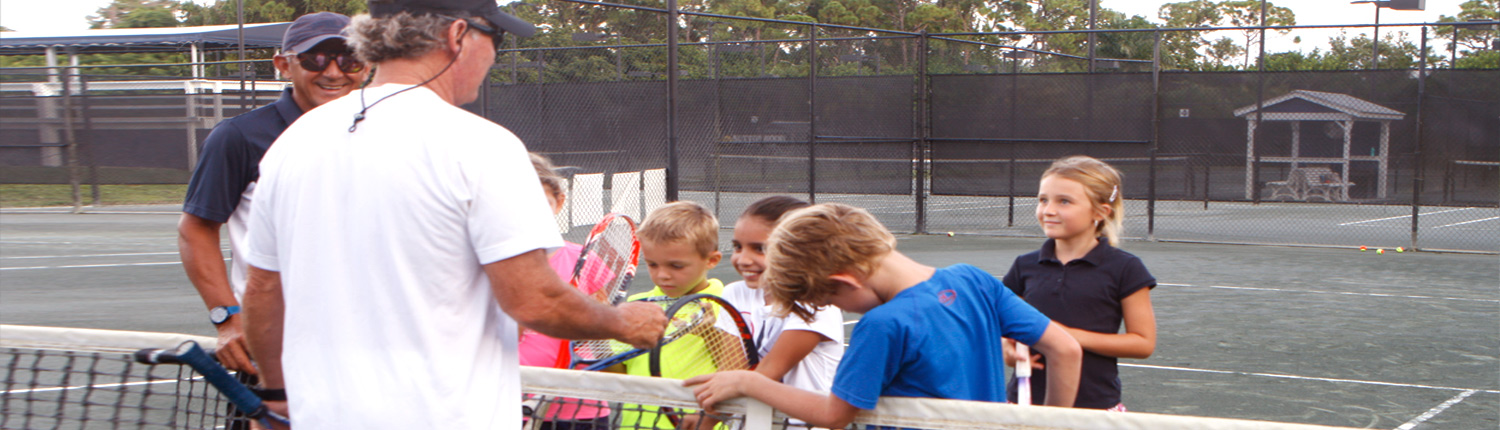 A group of children with their tennis coach